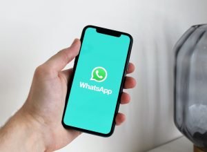 mão segurando celular apresentando o whatsapp