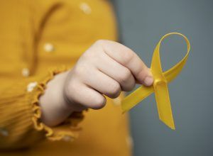 child-holding-yellow-ribbon
