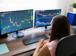 Close up of a business analyst investing in stocks online while working from home. Professional woman and freelancer in the trading business
